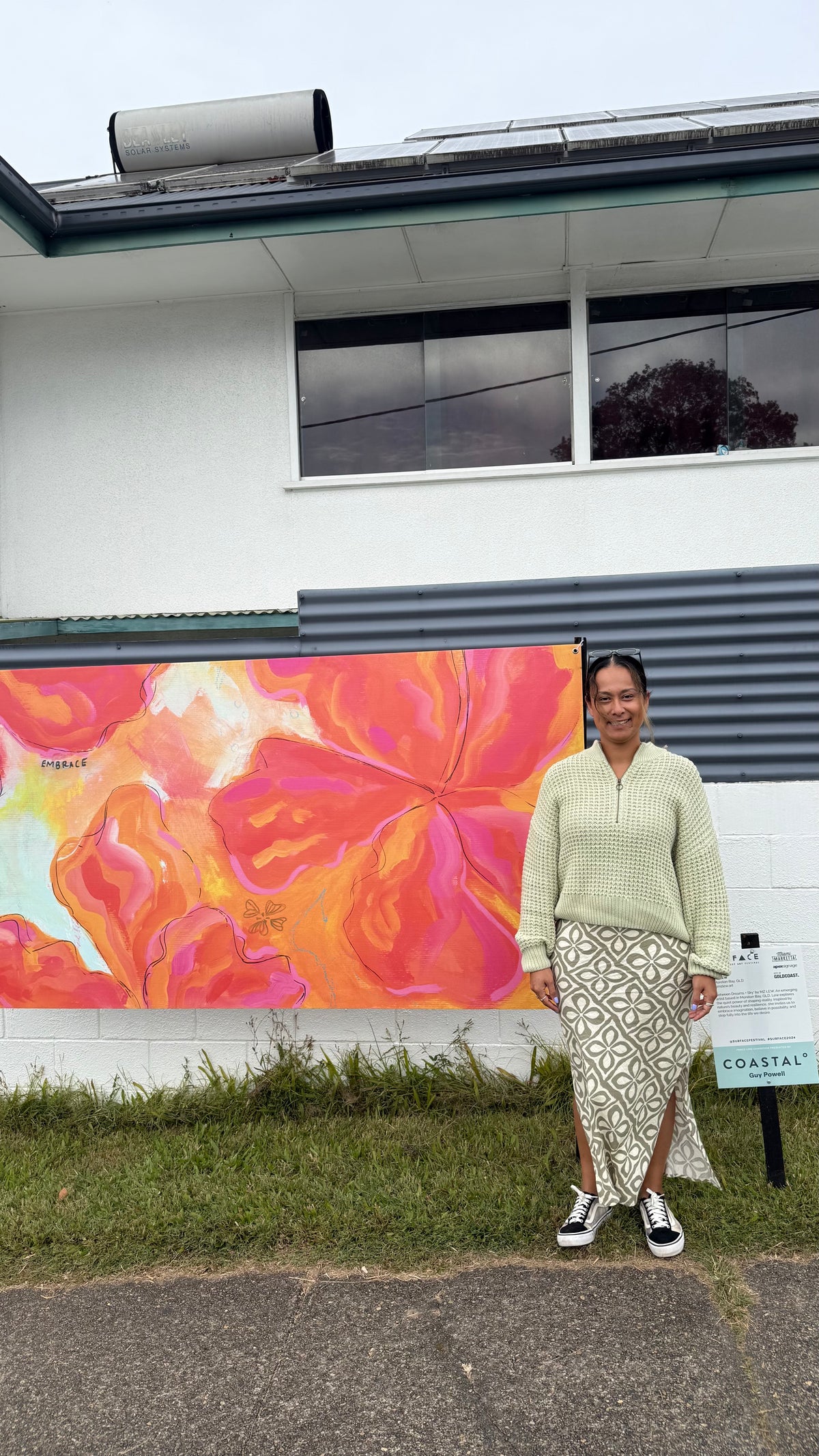 Lew in front of her artwork Between Dream and Sky selected for the 2025 Miami Surface Festival - Fenceline Exhibition. 