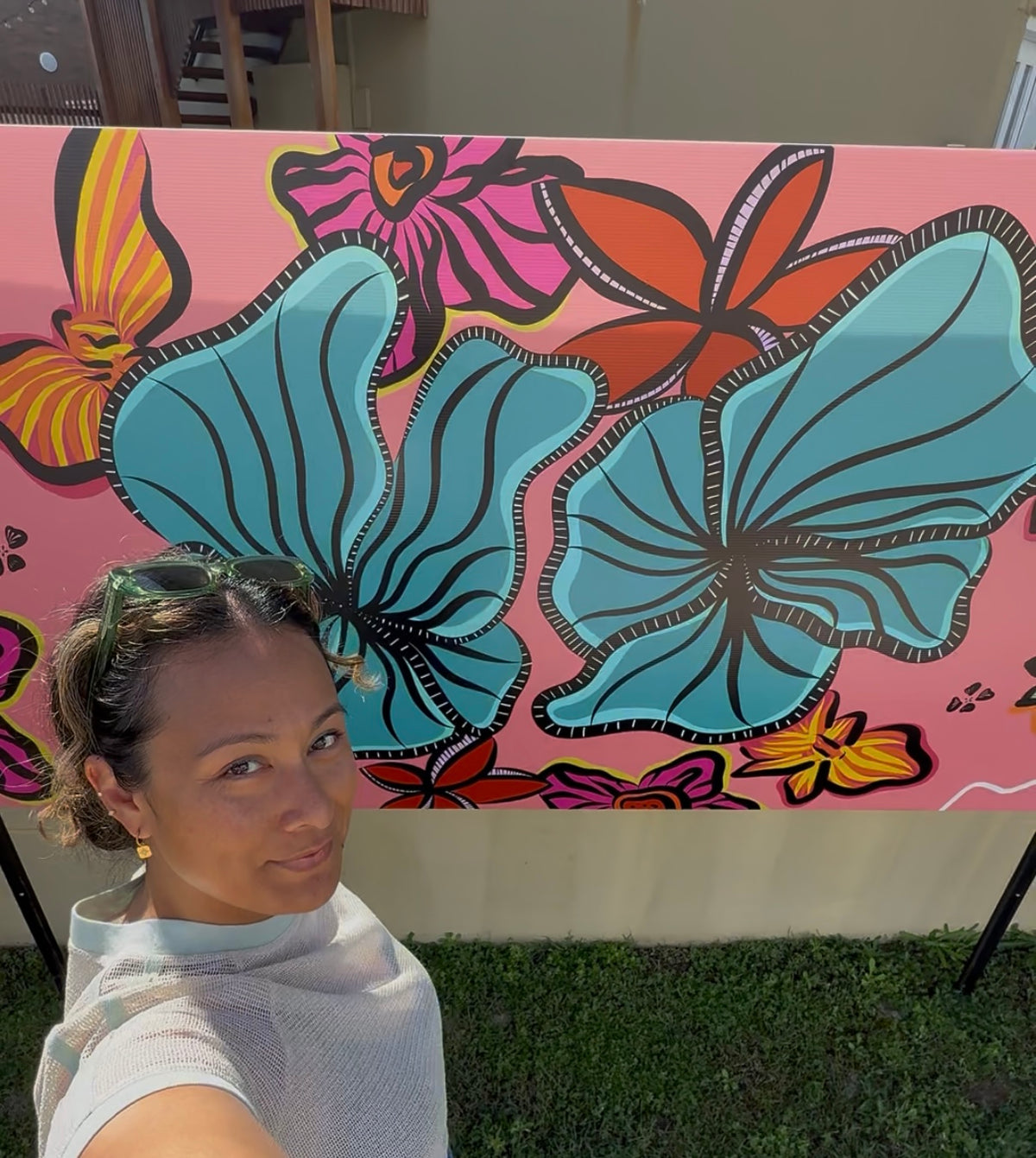 Lew in front of her colourful pink, blue, red artwork at Miami Surface Festival Fenceline Exhibition 2026. 